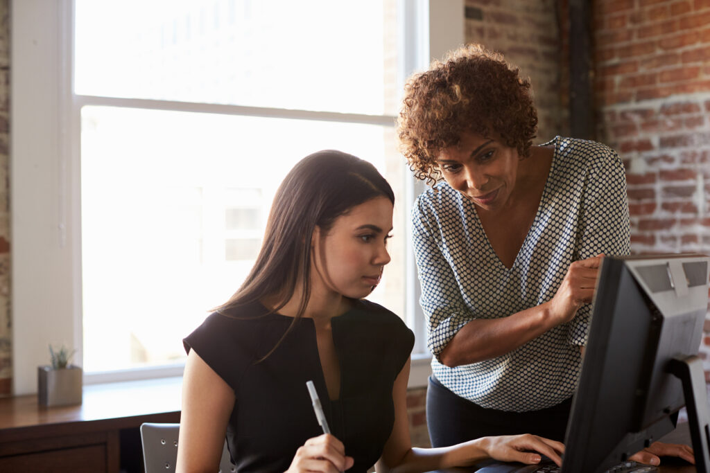 Two Businesswomen Working On Computer In Office By Monkey Business