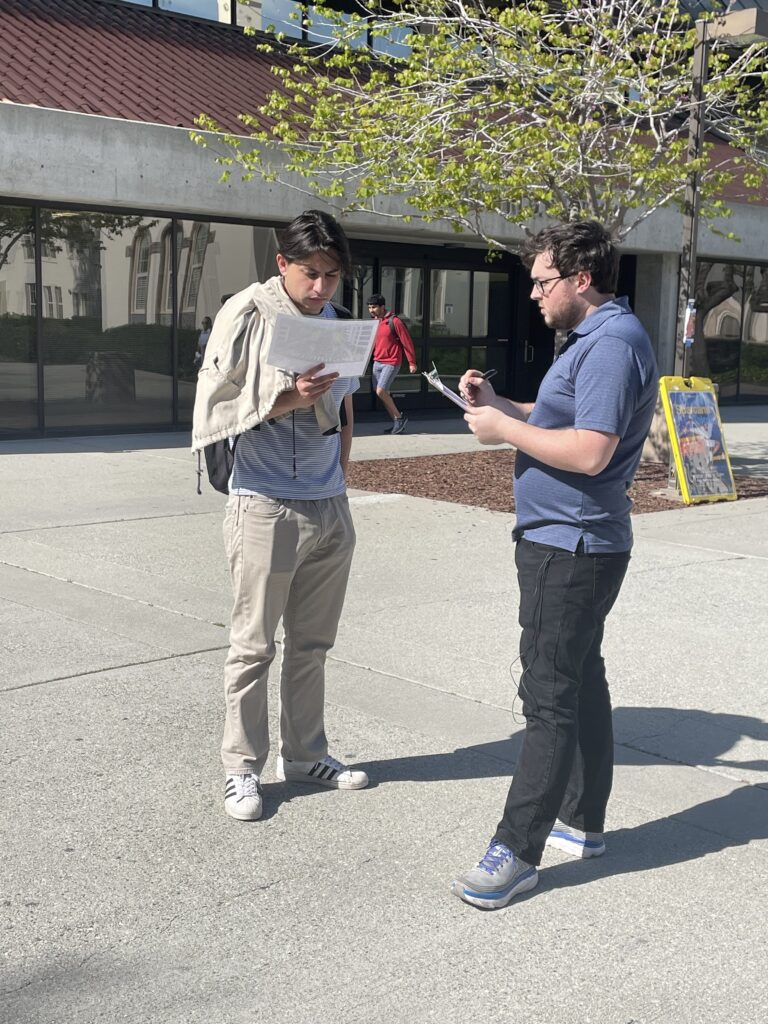 Student interviewing community member in plaza