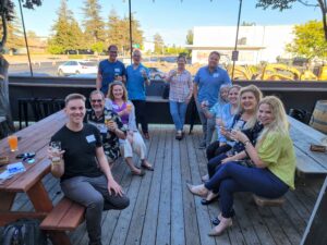 Group of people from the Northern Bay Area attending a Happy Hour at Henhouse Brewing Palace of Barrels in Petaluma looking into camera.