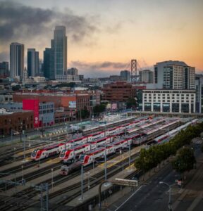 Aerial photo over the Caltrain station in San Francisco with the city skyline in the packground.