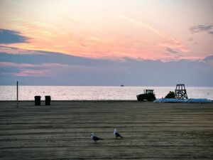 Photo of sunset taken from a pier overlooking an ocean.