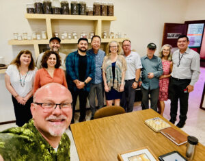 Picture of a group of people in a conference room gathered for a group picture smiling.