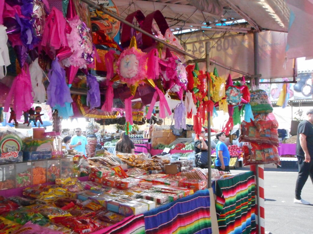 Piñatas Vibrant piñata stand with candies and piñatas hung from the stall cover.