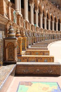 Photograph of a mosaic stairway with columns along the wall at the Plaza Espana in Seville, Spain.