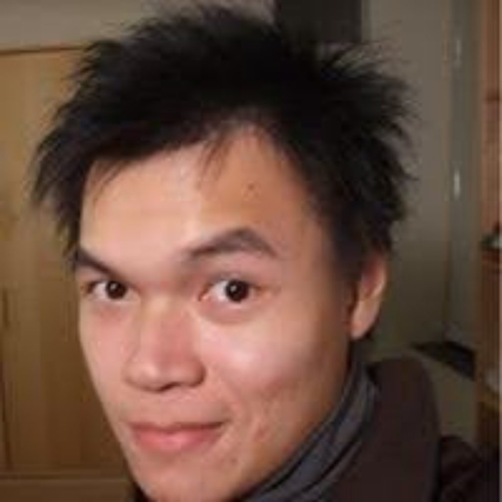 Headshot of a smiling young Asian man with black hair and brown eyes, wearing a black turtleneck shirt with dark grey jacket