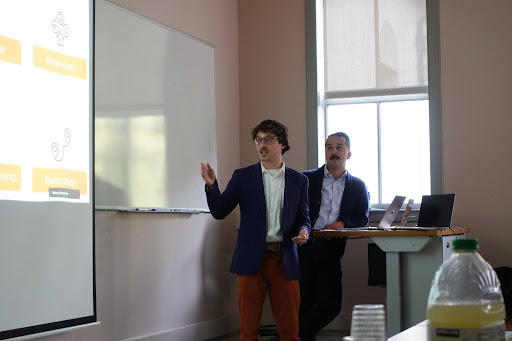 CapstonePresentation Two students give a presentation on site relocation analysis.
